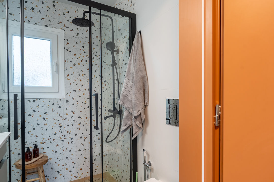 Glass rain shower with terrazzo tile detail