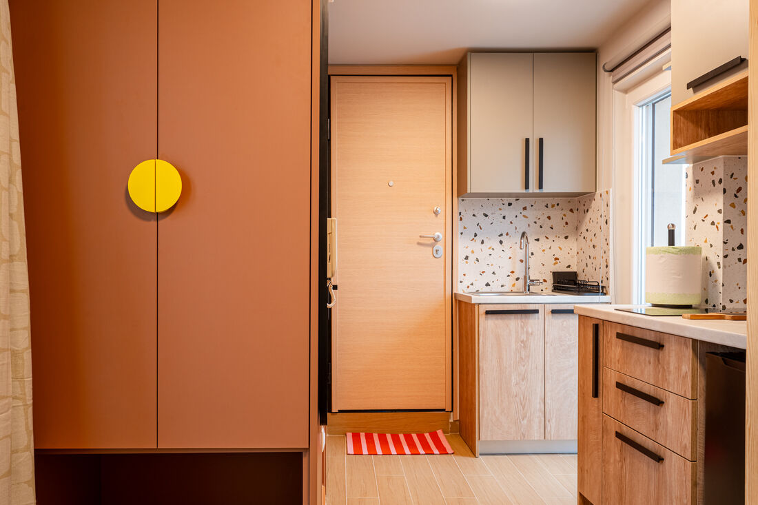 Kitchenette with terrazzo backsplash and wardrobe